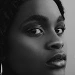 Black and white close-up portrait of a young woman with a focus on beauty and emotion.